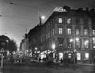 Hamngatan med Nordiska kompaniet i kvällsbelysning fotograferad från Norrmalmstorg, Stockholm.