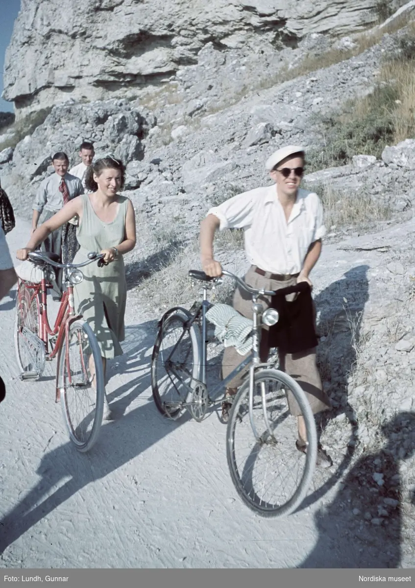 Två cyklister leder sina cyklar. Snäckgärdsbaden, Gotland