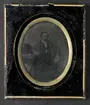 Porträtt av medelålders man, knäbild. Med mustasch, sittande, iklädd grå rock, svart väst, vit skjorta. Panotyp i ram, svartlackerat täckglas. Bakstycke av grått papper. 1850-1860-tal. Nordiska museet inv.nr 196100