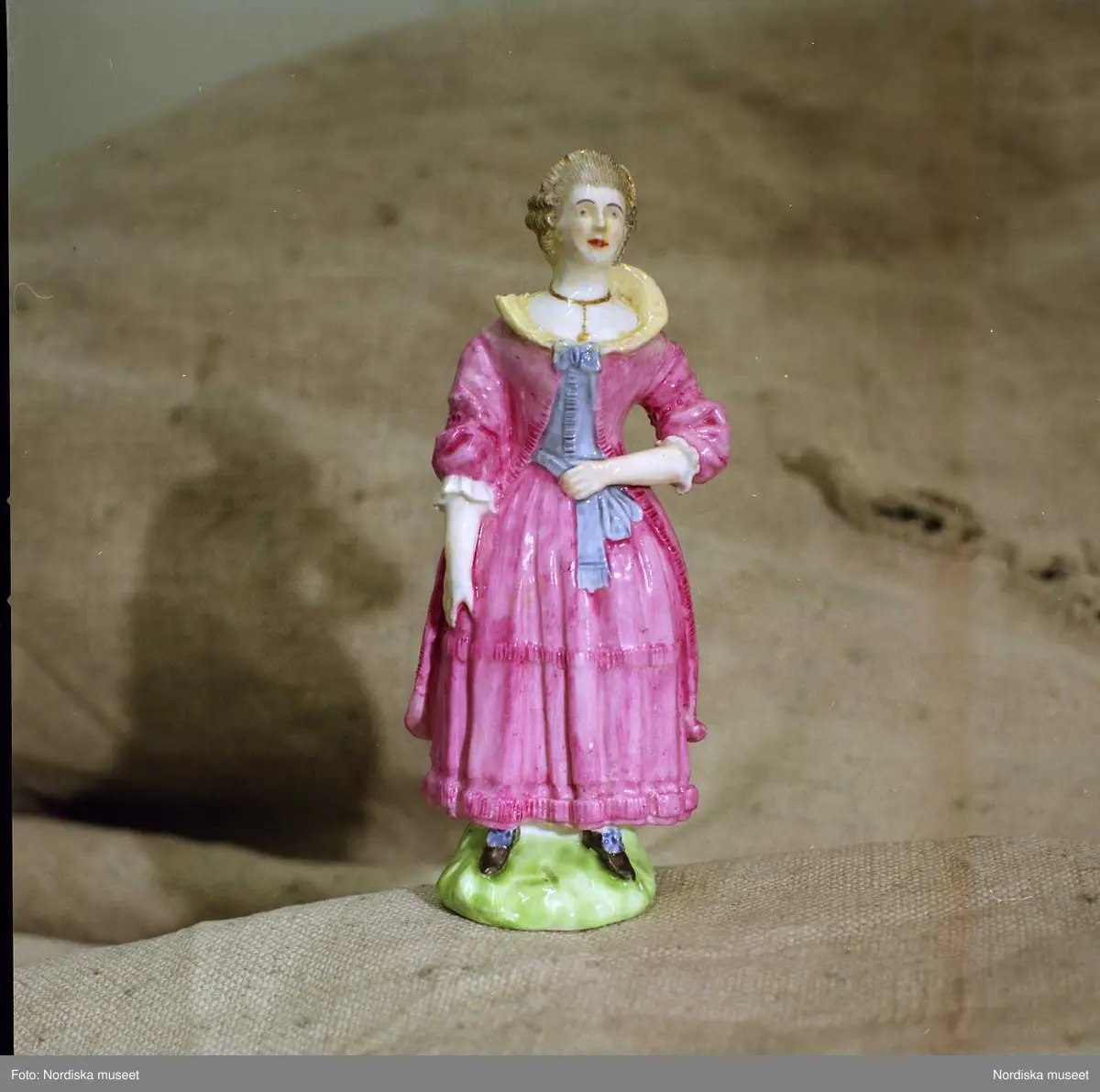 Figurin av porslin, tillverkad vid Marieberg 1769-1782. Dam i svenska dräkten. Nordiska museet inv nr 83514.