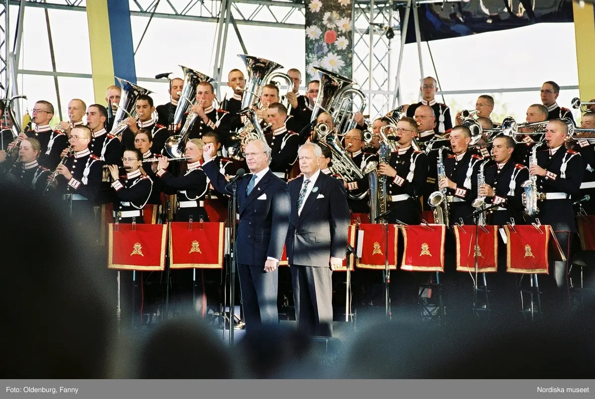 Firandet av den svenska nationaldagen den 6 juni 2004 på Skansen, Stockholm. Den kungliga familjen. Orkester. Publik. Artisterna Jan Malmsjö, Shirley Clamp, Magnus Carlsson.