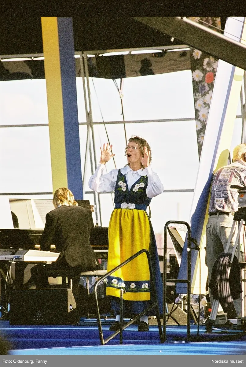 Firandet av den svenska nationaldagen den 6 juni 2004 på Skansen, Stockholm. Den kungliga familjen. Orkester. Publik. Artisterna Shirley Clamp, Tomas Ledin och Lasse Berghagen. Programledaren Agneta Bolme Börjefors.