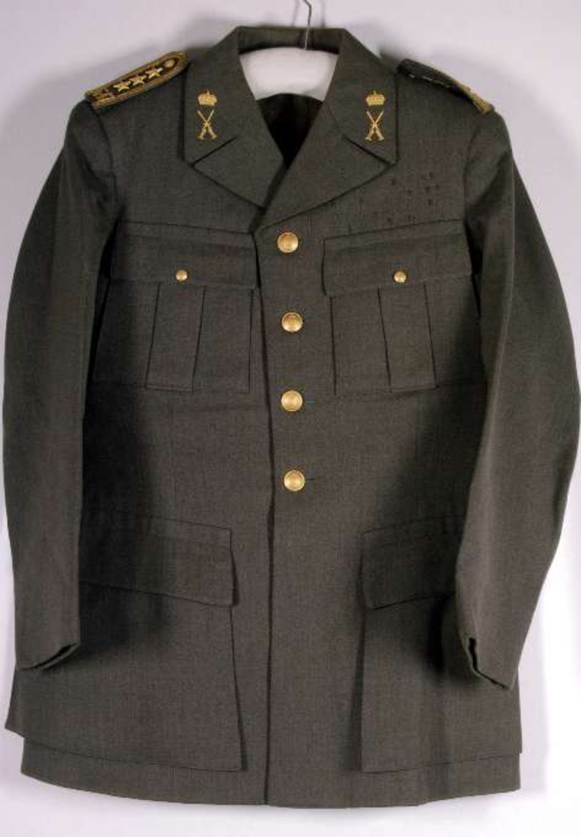 Uniform av diagonalvävt ylletyg. Guldgaloner och gradbeteckningar av gulmetall. Knappar av gulmetall med riksäpple. Fodrad med grått konstsiden. Skärp av brunt läder med axelrem. Skärp av metalltråd i guld och blått, läderfodrat, mässingsspänne. Uniformsmössa av grått kypertvävt ylle. Svart läderskärm, guldsnodd. Mässingsknapp och emaljkokard. Text: Arméns centrala beklädnadsverkstad. Skärmmössa med skärm av tyget. Båtmössa.