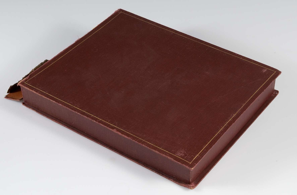 Album, inbundet i helfranskt band i brunt läder med stämplade ramverk och ornament i guld. På pärmens framsida spegelmonogram, komponerat av bokstäverna GEK (Gustaf E. Karlsson). Guldsnitt runt om, blad av mörkgrå kartong. Frontespis med textad tillägnan: "Till Direktör Gustaf  E. Karlsson 60-årsdagen 19 30/10 28. Med varm lyckönskan och tack för värdefullt arbete. Uppsala Specerihandlarförening". Albumet innehåller fotografier av Gustaf E. Karlsson, av hans speceriaffär, av styrelsen i Uppsala Specerihandlarförening samt av föreningens hedersledamöter och medlemmar. Albumet på pärmens baksida stämplat: "Levins Bokbinderi. Uppsala Bokband C W Bergman". Mapp, klädd med mörkbrunt läder. 