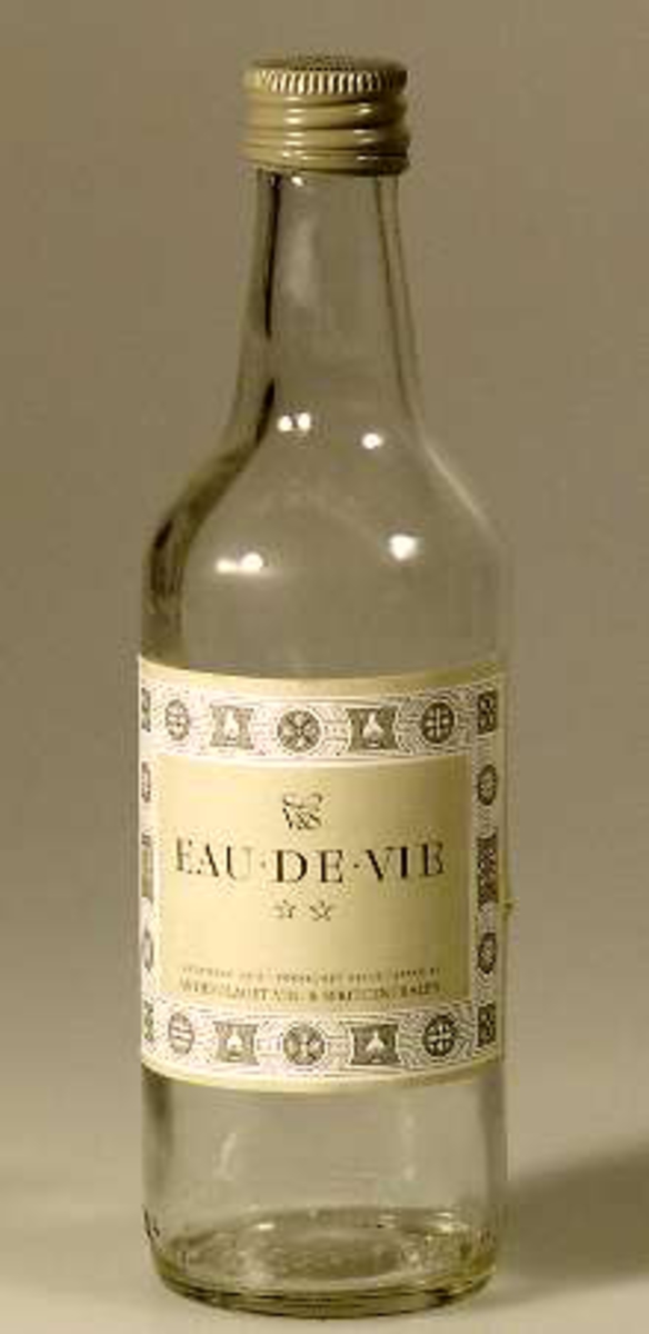 Flaska av glas med skruvkork och etikett av papper: EAU.DE.VIE Aktiebolaget Vin- & Spritcentralen.