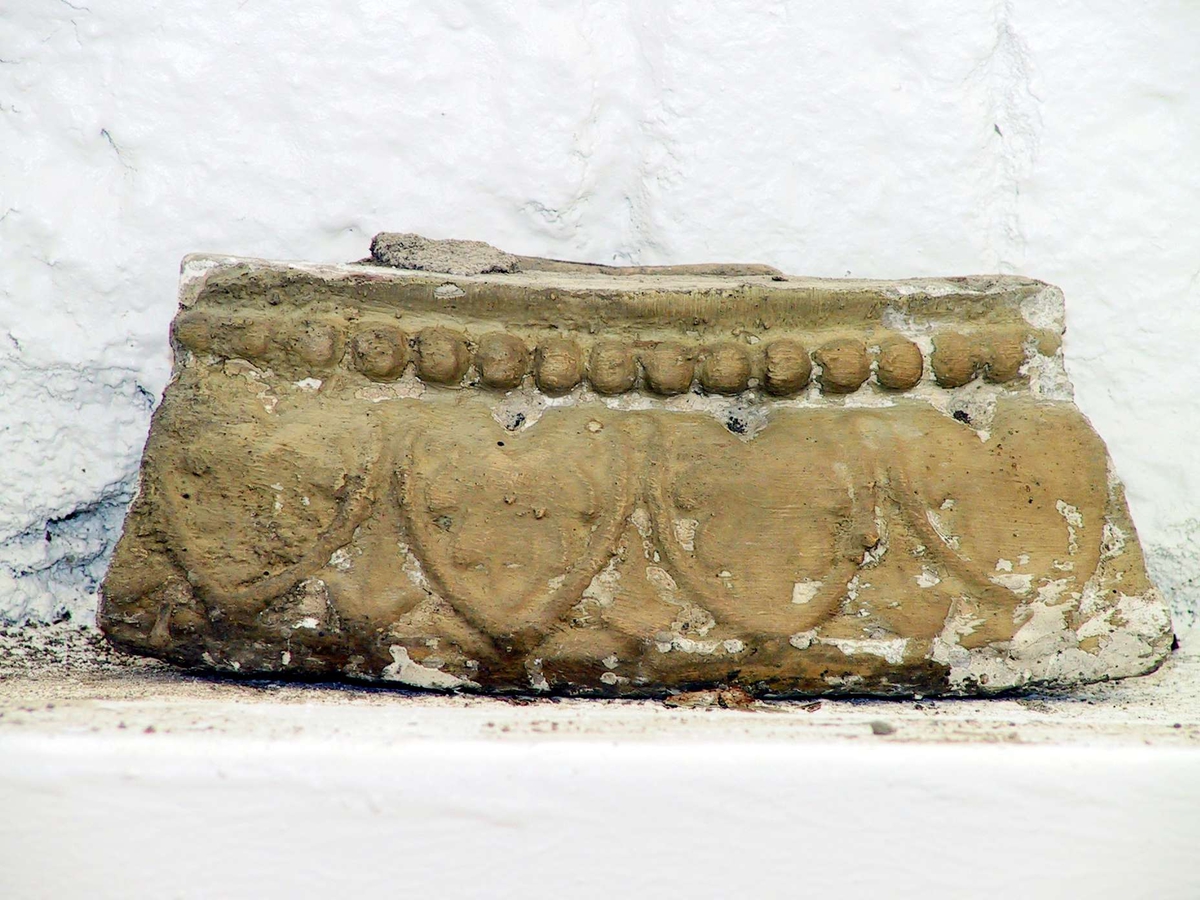 Kakel till rund kakelugn, målade med svagt gul och turkos färg. 45 hela kakel, 35 delar av kakel samt 26 delar till över- och/eller undersims. Vissa av kaklen har märkts med etikett med blå tunn ram.