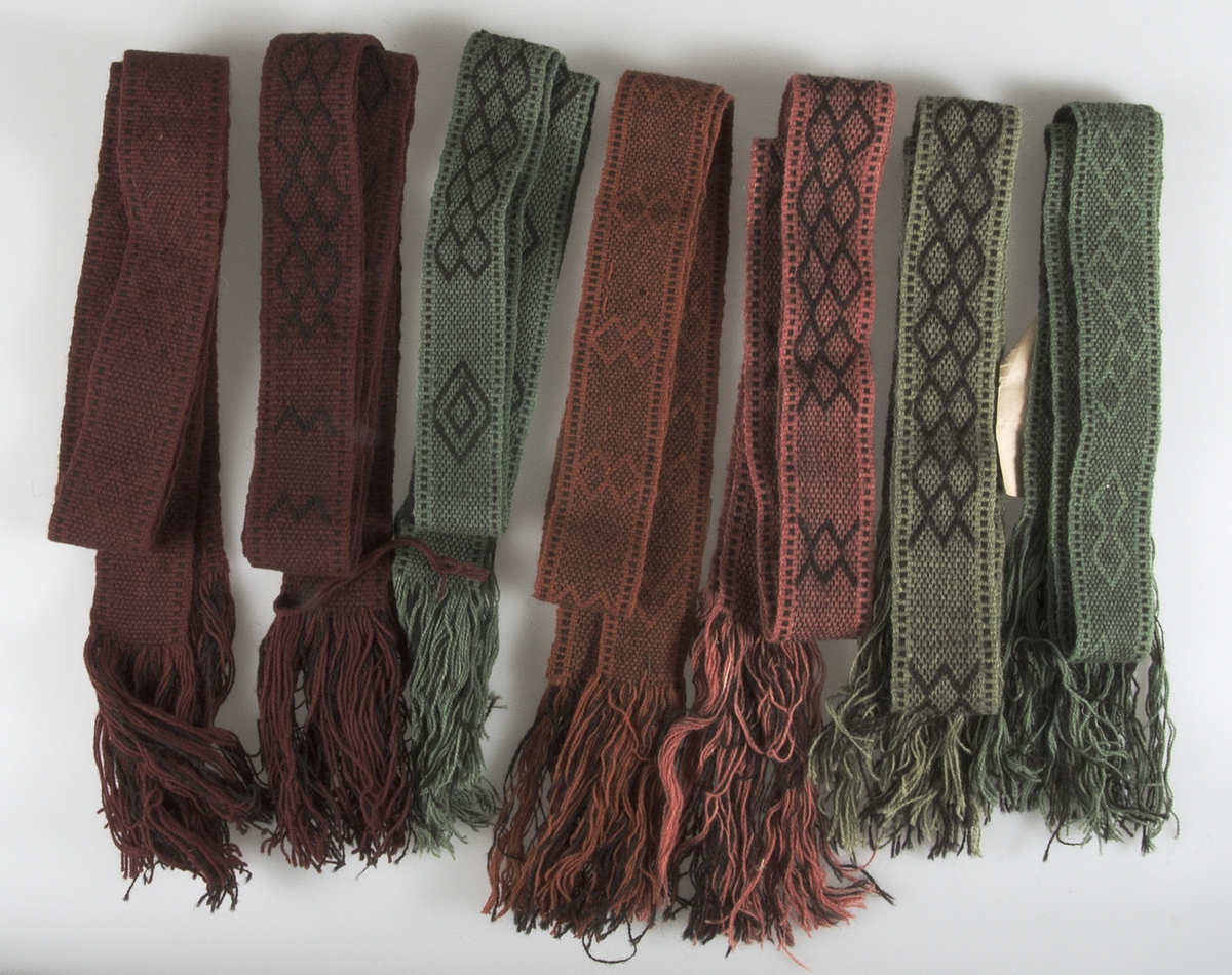 Sju stycken band vävda med tvåtrådigt ullgarn i vävtekniken upphämta. Tre av banden är i färgerna natursvart och grönt, två i färgerna i mörkt rött och natursvart, ett i rostrött och natursvart och ett i rosa och natursvart. Två av banden har inga etiketter eller någon märkning. Två har en pappersetikett med texten "UPSALA LÄNS HEMSLÖJDSFÖRENING Nr: B4141 Mka, cm 5 x 200, Pris 5:-, 2,50/m". I ena änden på två av banden finns en påsydd pappetikett med texten:
B4141
N:r 398 Stockholmsutställningen 1930
Hemslöjdshallen
Föreningens namn: Uppsala Läns Hemslöjdsförening
Adress: Upsala
Föremålets art: Pälsband
Föremålets storlek: 2 m.
Teknik: Opphämta
Teknikens ortsbenämning: Tulubband
Material: Svenskt lantfårgarn
Försäljningspris: 2:50 pr.m. 5:- st.
Kopia, bearbetning eller komposition: Kopia

Mått: Bredden varierar mellan 5,5 - 6,5 cm. Längden varierar mellan 2,18 - 2,40 cm, inklusive frans på mellan 17 - 21 cm.