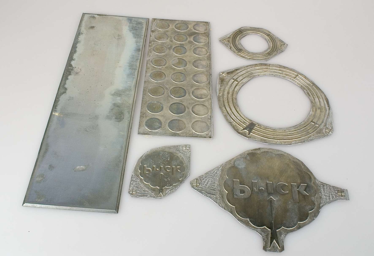 Sex klichéer av metall, olika storlekar och former. Alla klichéerna har förvarats i samma paket, inslaget i brunt omslagspapper på vilken en etikett med texten: Aktiebolaget Herman Stenberg, Textilvägen 7, Stockholm, var fäst. Klichéerna var monterade med tejp på bruna pappskivor med handskriven text: Pricks Bärkassar. Klichéerna togs loss från pappen i sambandmed katalogiseringen. I samma paket fanns skisser och förlagor till en papperskasse samt ett exemplar av den färdiga kassen.