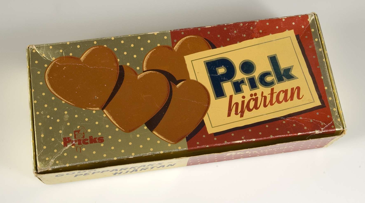 Förpackning av papp från Pricks Bagerier AB, i guld och rött. Pepparkakshjärtan på locket samt texten " Prick hjärtan" samt loggotypen Pricks med en liten bagare. På framsidan står: Goda pepparkakshjärtan Pricks fabriker Tierp. På baksidan: "Ni har väl smakat Pricks Maränger, Wafers och Pepparkakor". På undersidan: "Pricks Tierp Härligt goda kakor. Landets mest sålda. Köp dem Njut dem. Prick för den goda smaken". Som motiv finns också en buss med logotypen Pricks.