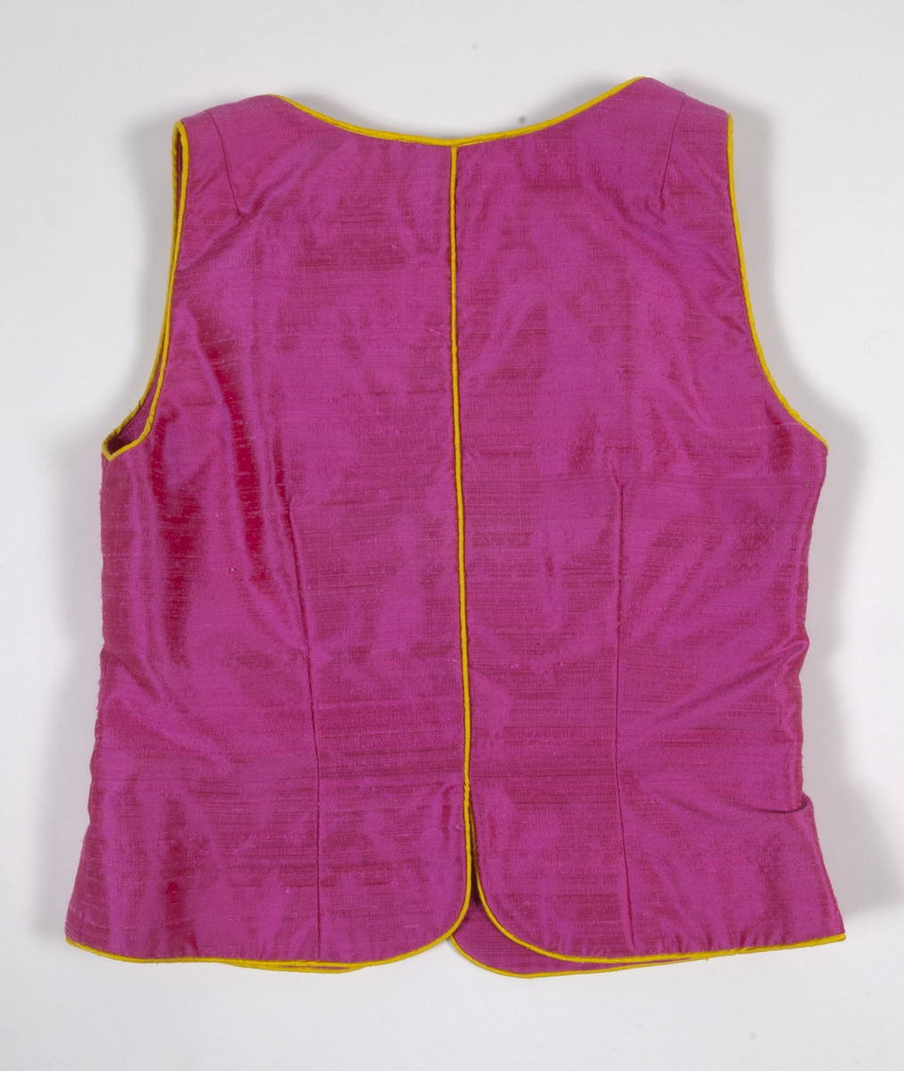 Ärmlöst liv i rosa siden. Livet är formsytt och kantat i gult siden. Livet knäpps på framsidan med agraffknäppning med fem guldfärgade plastknappar som har formen av rosor. Dessa är knäppta med agraffknäppning med öglor i gult siden.Livet är fodrat med rosa fodertyg.