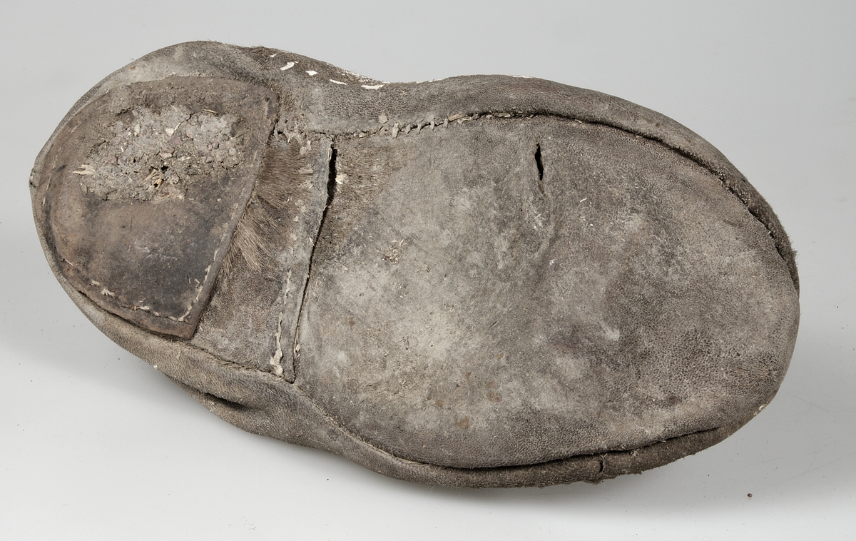 Känga tilllverkad av sälskinn som tillverkats i flera stycken. Sulan är förstärkt vid hälen av amma typ av skinn som övriga skon. Kängan stängs med hjälp av skinnremmar. Hårsidan utåt.