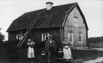 Familjen Uno V Nyberg framför ett bostadshus på Stora Väsby gård, Almunge socken, Uppland. I bakgrunden en piga med yngsta dottern.