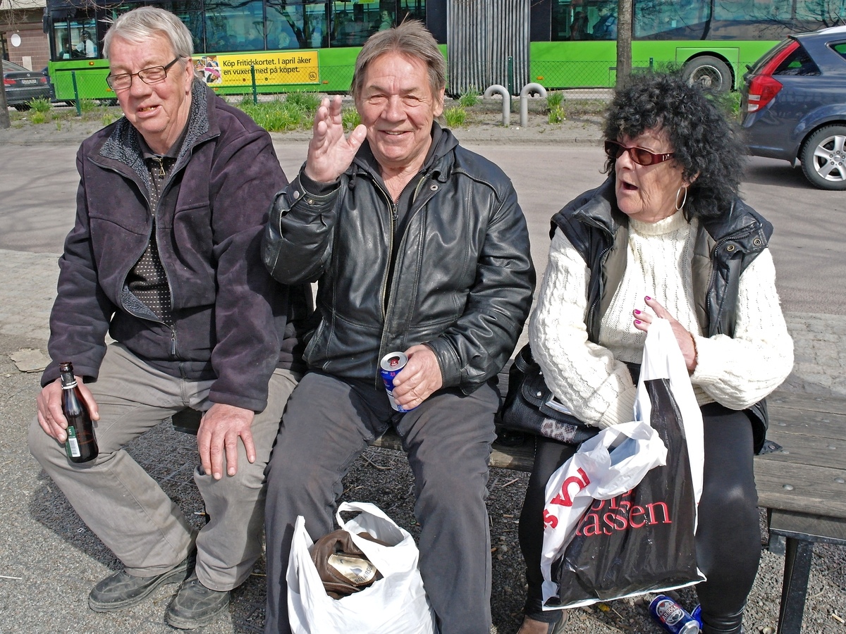 Kvinna och män på parkbänk, Vaksala torg, Uppsala 2011