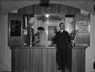 Torsten Walin framför disken, hans hustru brygger kaffe, nuvarande Café Alma, Universitetshuset, Uppsala 1941