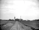 Landskapsvy med Breds kyrka, Breds socken, Uppland april 1919