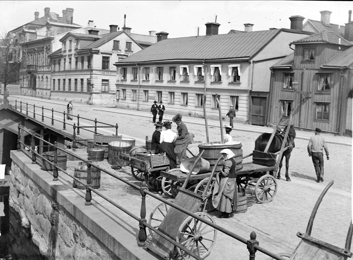 Hästekipage och kvinnor vid tvättstugan i Fyrisån, Östra Ågatan, Uppsala 1900