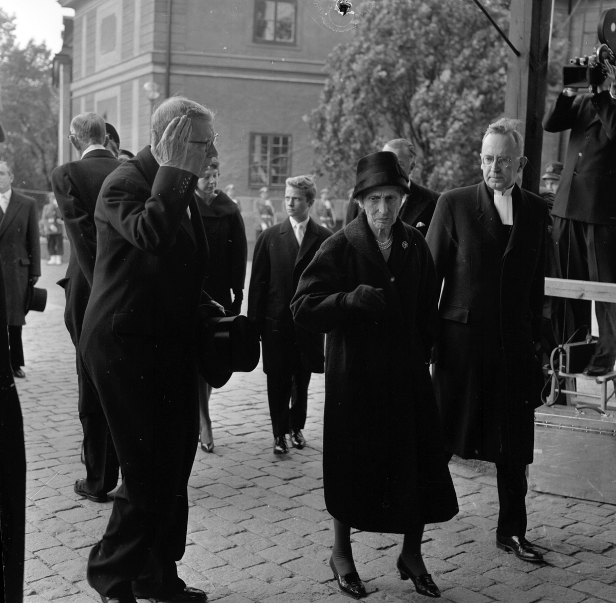 Dag Hammarskjölds begravning. Utanför Uppsala domkyrka före jordfästningen. Kung Gustaf VI Adolf och drottning Louise på väg in i kyrkan. Uppsala 29 september 1961