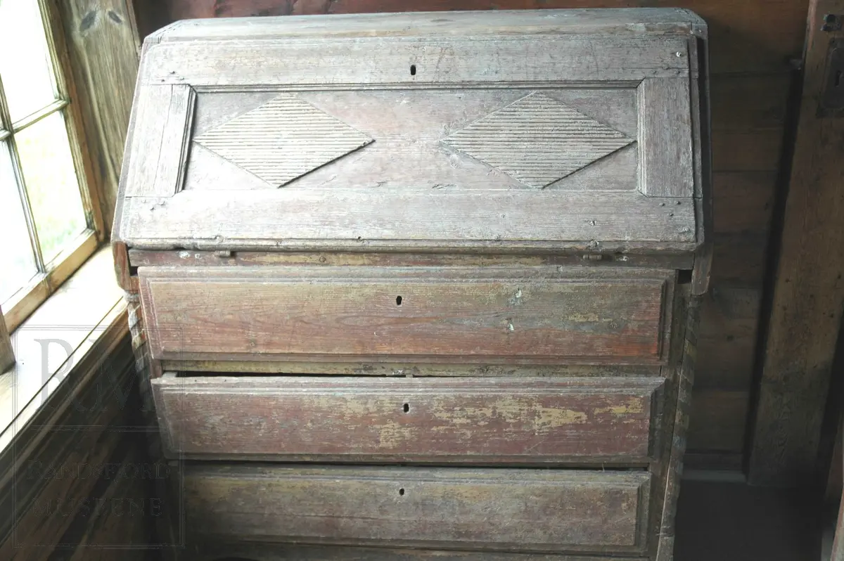 Med tre skuffer og nefellbar klaff. I klaffen er det rilledekor i to ruter-felt