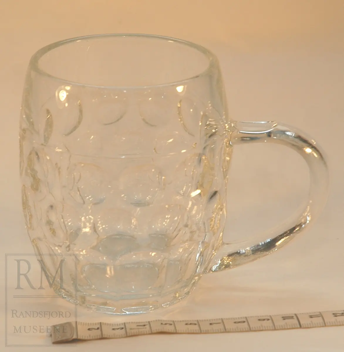 Kraftig krus i klart glass. Sirkelformet mønster på utsiden. Hank.
