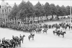 Parad på Gustaf V:s födelsedag 1928. Förbimarsch för platschefen överste Reuterswärd på skolplan framför Eric Ugglas skola. I bakgrunden till vänster milostabsbyggnaden.