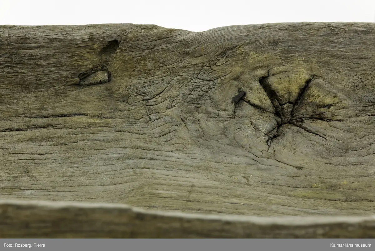 KLM 45167. Båt, stockbåt. Av urholkad trädstam. Huggen i ett stycke. Rektangulärt, något fallande tvärsnitt. Sprucken i fyra delar men de kan lätt sättas samman. I aktern en köl som saknar partier. Kölen sträcker sig fram mot toften, sittbrädan, i båtens akterdel. I toften ett borrat hål. I bottnen på styrbord sida ett hål med en träplugg i, likaså babord reling har ett sådant hål. Fören har blivit lagad vid någon tid och ett stort stycke saknas. I akterns ände tre borrade hål men träpinnar i. Små borrade hål och lagningar med järndobbar, framför allt i fören.