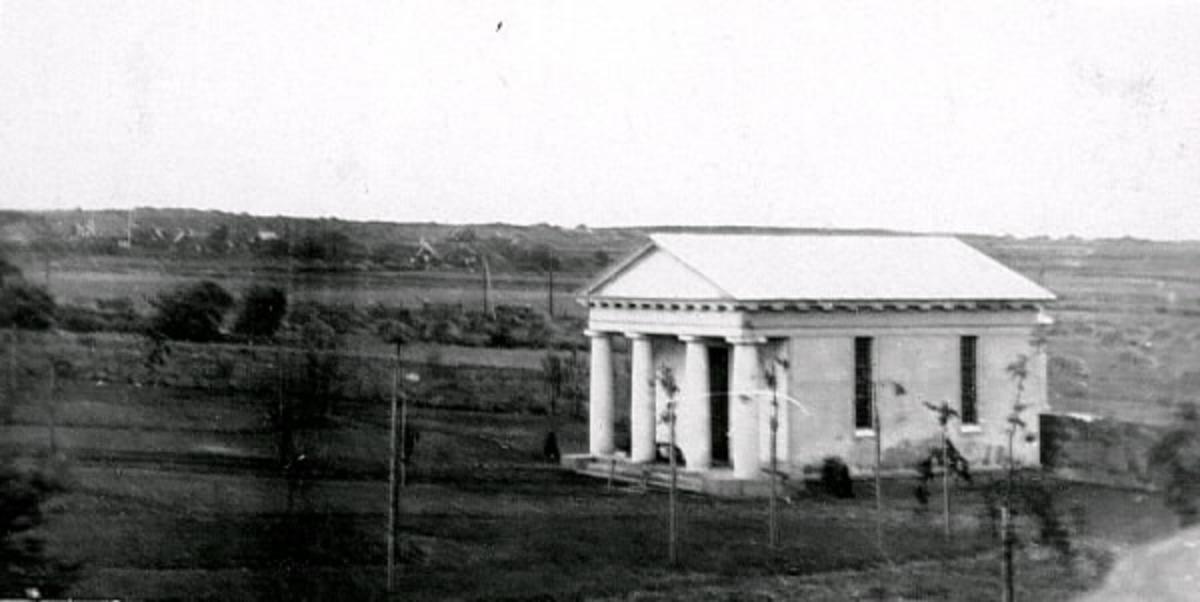 Gravkapellet på Kustsanatoriet Apelvikens kyrkogård i Varberg. 
Bilden var publicerad i Hallands Nyheter, 1944-04-29 i artikeln "Där soldoktorn vilar". I bildens nederkant ses flera nyplanterade träd och inga vita kors syns, så troligen är fotografiet äldre.