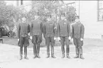Underbefäl ur K 2 som genomgått armens underofficersskola, (tresterckad furir) tjänstgörande vid aspirantskolan tillsammans med fyra elever från K 2 Häsingborg i uniform m/1895 (m/ä). Till vänster i bild aspirant Ask. Gruppbild.