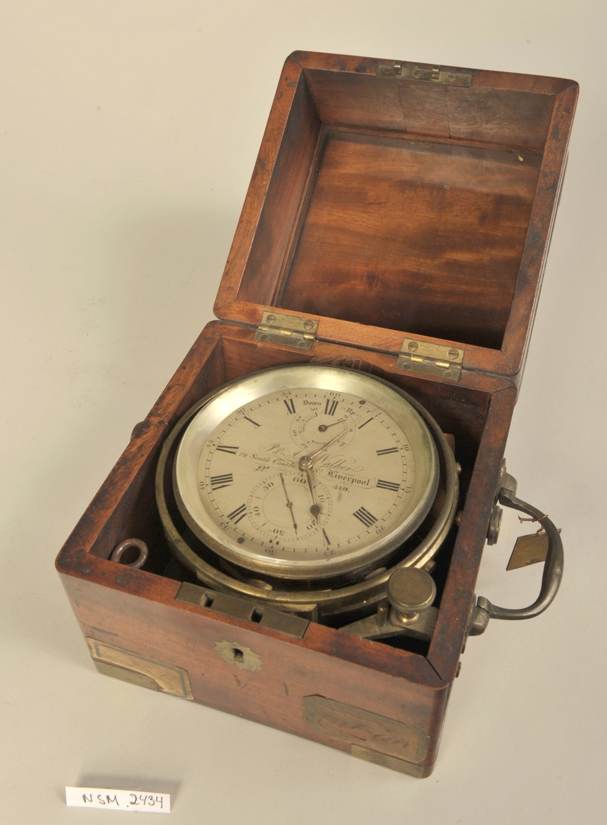 Kronometer i trekasse. Kassen har håndtak og detaljer i messing.