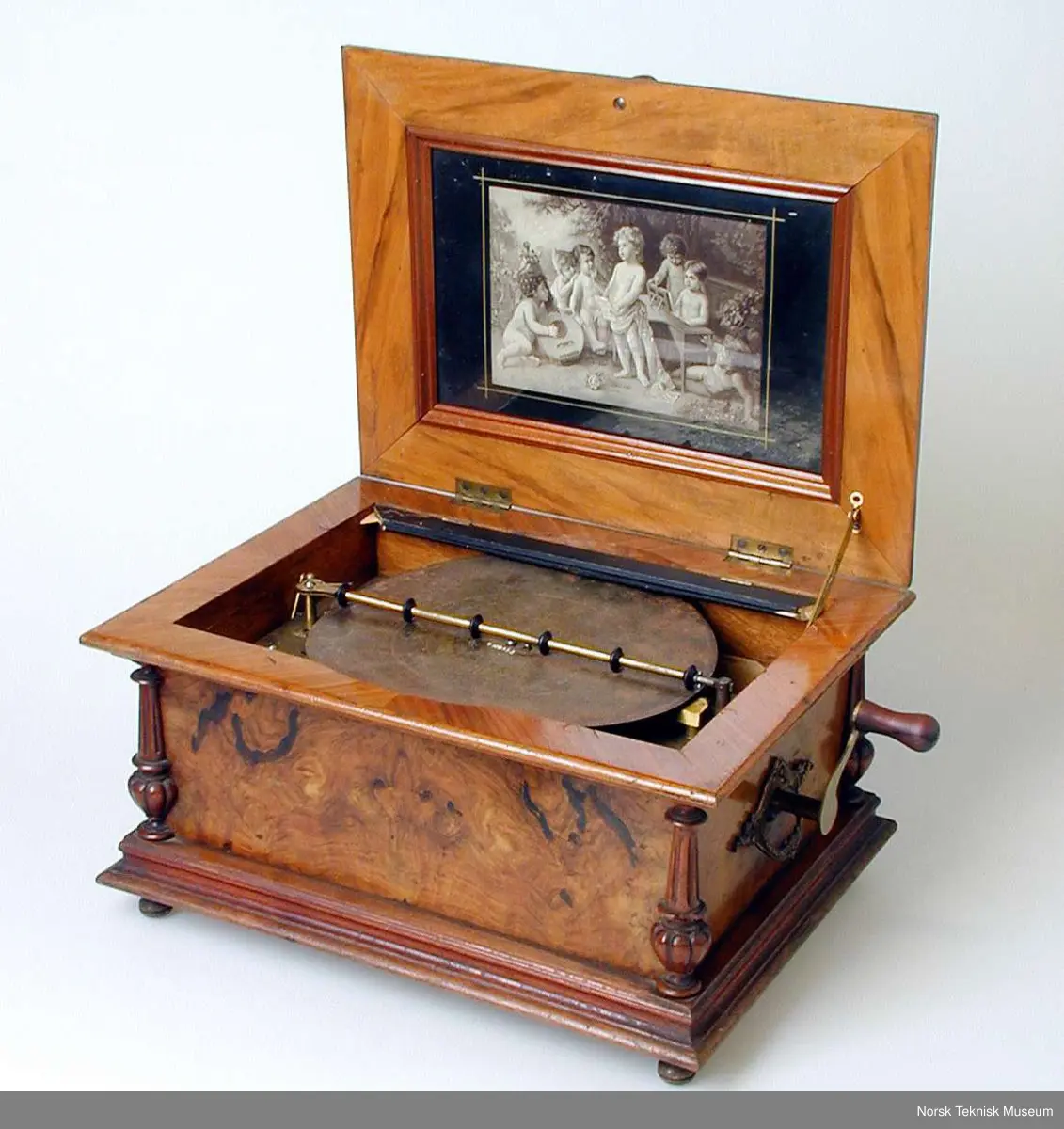 Med en plate: Die Morgenglocken. Nr. 3082. Bilde nr. 6 viser en tilsvarende spilleautomat i god stand. Den viser at det opprinnelig har vært et glasslokk over platen. På den registrerte gjenstanden er bare deler av den sorte rammen som glasset har vært festet i igjen.