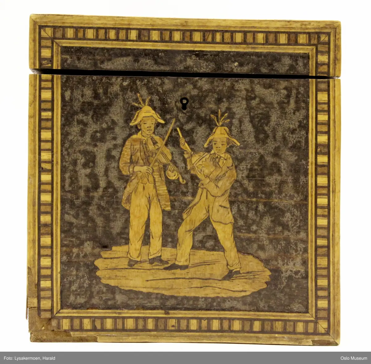 Alle fire sider og lokk har innlagte motiver i gullfargede og brune sjatteringer. (Se foto).