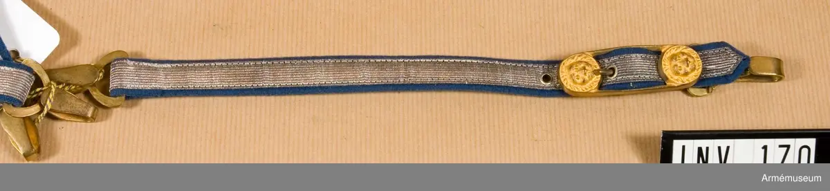 Dragrem av silvergalon, denna är 13 mm bred. Foder av blått  kläde. Långsmalt spänne av gulmetall, 60 mm långt och 20 mm  brett, m två lejonhuvuden, ett i var ände. En hake i var ände.
Källa: Knötel, band II Formations und Uniformierungsgesichte.