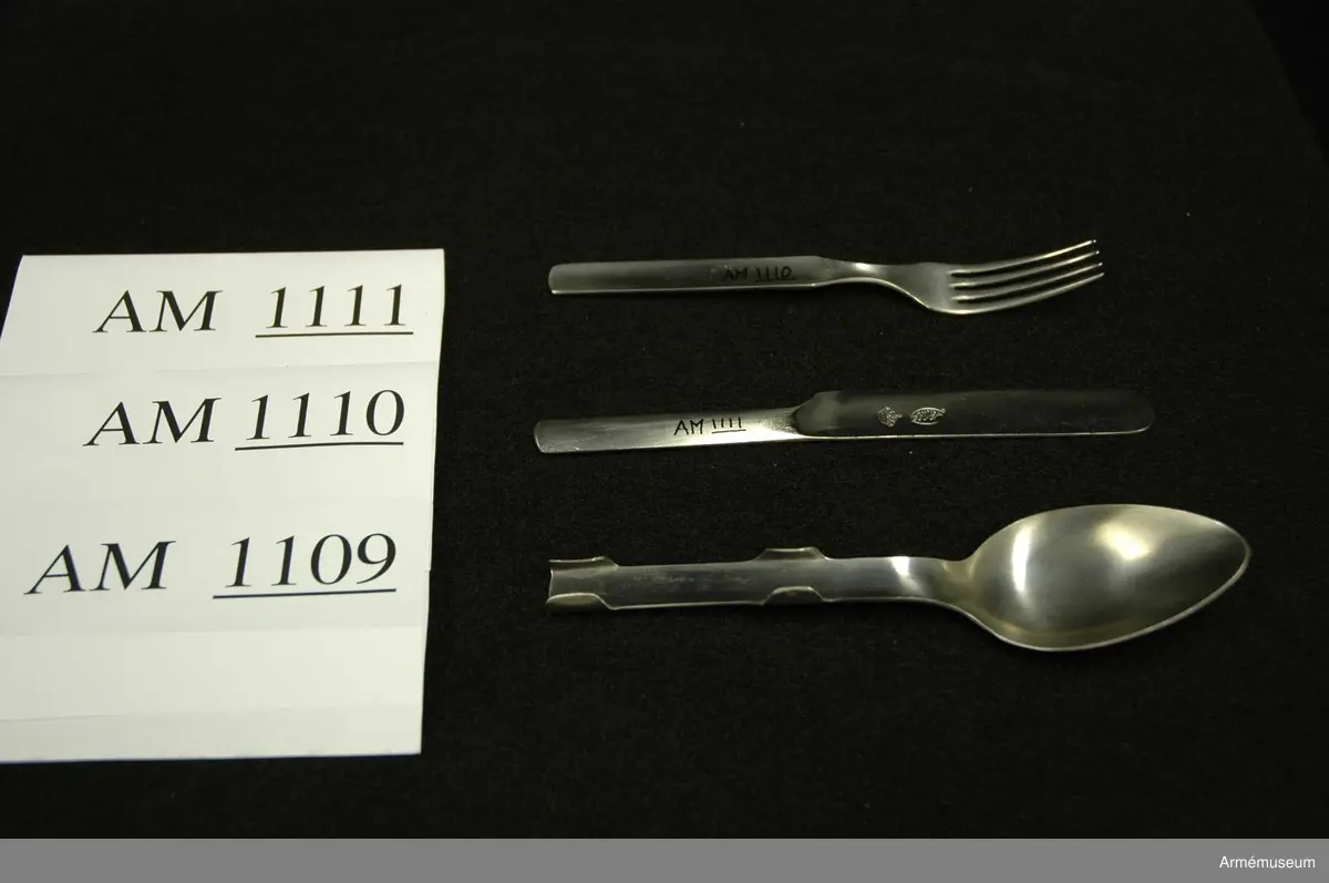 Samhörande nr är 1074-1129, (1109-1111).
Kniv m/1929.
Utförd i ett stycke och saknar egg. Liksidig. På bladet står "GENSE ROSTFRITT" samt en kunglig, sluten krona. Kniven förvaras under transport och förvaring instucken i skeden tillsammans med gaffeln. Har tillhört mob.utrustning vid Armémuseum.