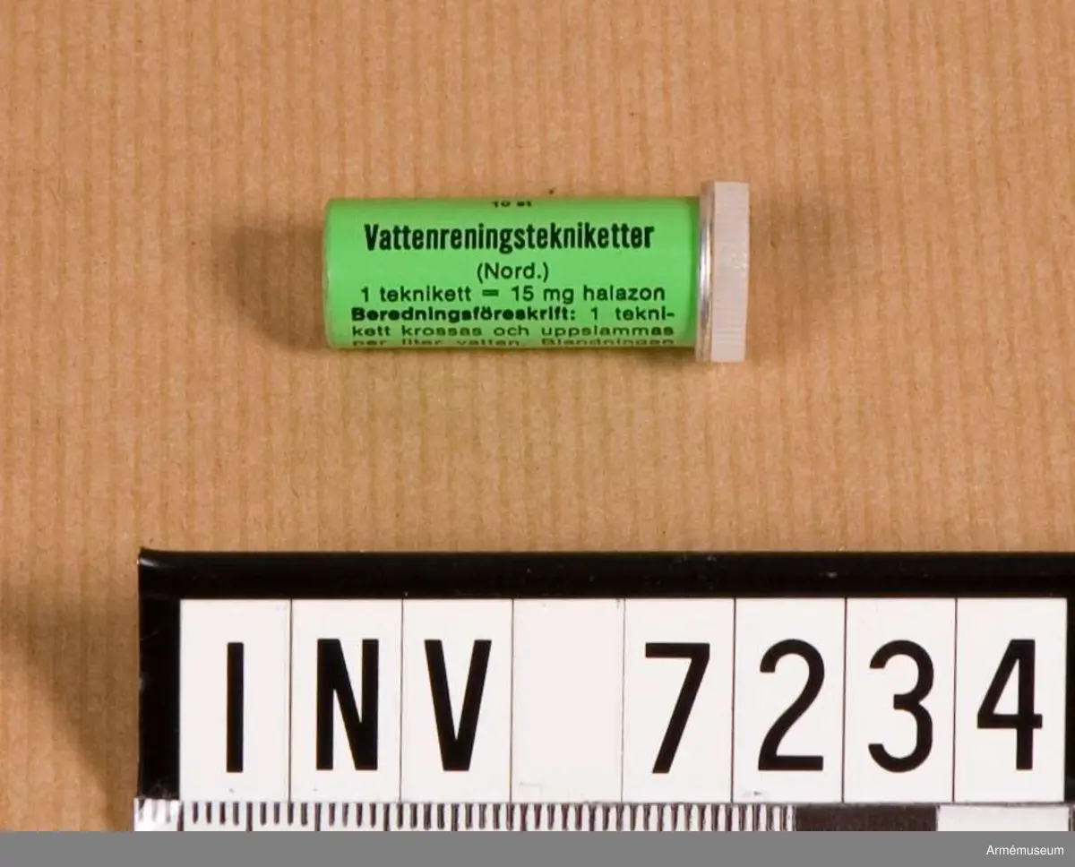 Behållare med tekniketter för vattenrening.
Ett litet grönt rör med lock. Text finns på behållaren med användningsföreskrifter.  
Innehåller 10 st tekniketter som skall lösas i vatten.  
Klortabletterna är sexkantiga och vita.