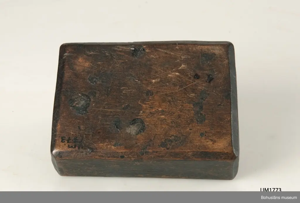 Rektangulär låda med två skjutlock, vilka dras ut åt varsitt håll.
I det större facket förvarades en flintbit eller ett eldstål och i det mindre fnösket att fånga gnistan med.
Den svartmålade färgen har flagnat runtom.
Något skadedjursangrepp.

Litt.; Gjaerder, Per, Esker og tiner, C. Huitfeldts förlag, Oslo, 1981, s. 48-50.

Ur handskrivna katalogen 1957-1958:
Ask, dubbelt skjutlock
Bottenmått. 12,5 x 8 H: 4
Trä, brunmålat. Föremålet helt. Forshälla, Bohusl.

Lappkatalog: 84