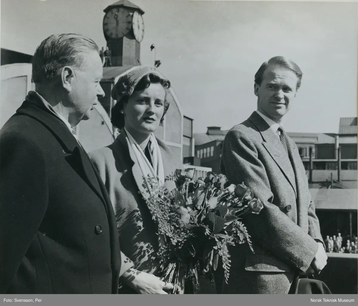 Direktør Aamundsen, gudmoren og Fred Olsen på tribunen før dåp og stabelavløpning av cargolineren M/S Burrard, B/N 508 på Akers Mek. Verksted 21. april 1956. Skipet ble levert i 1956 til Fred. Olsen & Co.