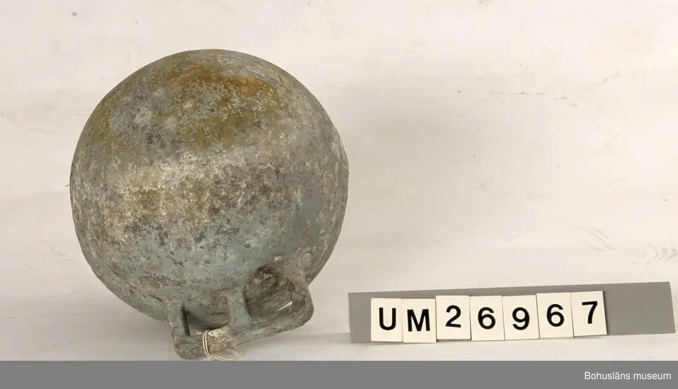 Fem klotformade flöten av metall (aluminium eller zink?). Beskrivningar av flötena i storleksordning följer här:
1. Omkrets 64 cm, med tre upphöjda ränder runtom på mitten och korta upphöjda ränder på tvären mellan dem på några ställen. I utstickande rektangulär del med rundade hörn finns två runda hål bredvid varandra. Text i relief: MANUFACTURERS PHILIPS ...(Oläsligt) TRAWL PRODUCTS GRIMSBY? ENGLAND ? (Svårlästa ord). Oläslig text p g a att den är bortsliten även på ytterligare ett ställe. Slitet.
2. Omkrets 63,5 cm, med sju upphöjda ränder, den mittersta bredare än de övriga. Två rundade metallöglor med gemensam mittdel sticker ut. Text i relief: AUTRIEB ? (Svårläst)...(Oläsligt) Märke som ser ut som ett kantigt stort S och siffrorna 197. Mycket smutsigt, fläckvis vit beläggning.
3. Omkrets 63 cm, slät yta utan upphöjningar, målad i vitaktigt grönblått i två olika nyanser, färgen delvis avsliten. Utstickande del med två närmast fyrkantiga hål. Text i relief: ... (Oläsligt ord) DE ... (Oläsligt ord) PARIS. Stor rostfläck. Mycket slitet.
4. Omkrets 55,5 cm. Med fem upphöjda ränder runtom. Rundad del med två kvartcirkelformade hål sticker ut. Text i relief: MADE IN SPAIN LA CORONA, bild av en fyr med ljusstrålar samt patentnummer med 39 siffror i. Samma? text/bild/siffror finns på ytterligare ett ställe fast är där mer sliten. Slitet.
5. Omkrets 37 cm. En upphöjd rand på mitten, för övrigt slät yta. En ögla sticker ut på ett ställe. Knutet runt den finns rester av snöre. Slitet. Rostfläckar m fl fläckar.

För uppgifter om brukaren se UM026962
Se även Bohusläns museums arkiv, arkivnummer 389.