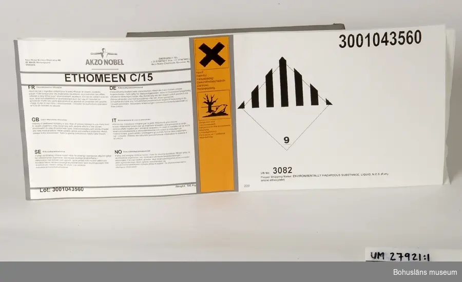 Föremål  insamlade i projektet Oil Field Girls - petrokemisk industri i Stenungsund 2003-2004.

Exempel på etiketter av förklistrat plastat papper att fästa på plåtfat.
Avser märkning av plåtfat innehållande
ETHOMEET C/14
Kokosalkylaminetoxilat
Två vita avlånga likadana etiketter med svart text, tillverkad för Akzo Nobel Surface Chemistry AB. 
I övrigt märkta med omfattande text, bl. a orange varningstext  märkt "Hälsoskadligt" och "Miljöfarlig" på flera språk och "Mycket gifitg för vattenlevande organismer, kan orsaka skadliga långtidseffekter i vattenmiljön."
Weight: 195 kg
Oanväna.

Etikettsystemet som gällt fram till år 2002 har inneburit ca. 5 etiketter  per fat. Det nya systemet innebär att all information finns på en jättelång etikett som skall sitta på sidan av faten eftersom man i framtiden  skall lagra faten stående.

Sammanhör med UM27920.

Föremålen är resultatet av en direkt inbjudan till deltagarna i projektet att föreslå föremål som skulle kunna samlas in till museet. Plåtfaten finns med i webbutställningen men det var insamlingsgruppen som föreslog att vi skulle ta in ett plåtfat till museet. En väldigt liten del av Akzo Nobels produkter levereras  annars i fat, det mesta går via rör till båtar i hamnen. Det är väldigt speciella produkter som sänds i fat. 

Föremålen UM27901 ff. ingår i Delprojekt I : Oil Field Girls - petrokemisk industri i Stenungsund, ett metodutvecklingsprojekt kring den petrokemiska industrin i Stenungsund. Bohusläns museum har i projektet velat pröva och utveckla en metod, där olika grupper i Stenungsund och på industrierna involverats i en insamlingsverksamhet kring Stenungsunds industriella näringsliv och petrokemiska tillverkning.