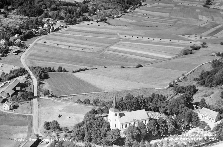 Enligt AB Flygtrafik Bengtsfors: "Torp Bohuslän".
Enligt text på fotot: "Flygfoto över Torps kyrka Orust"