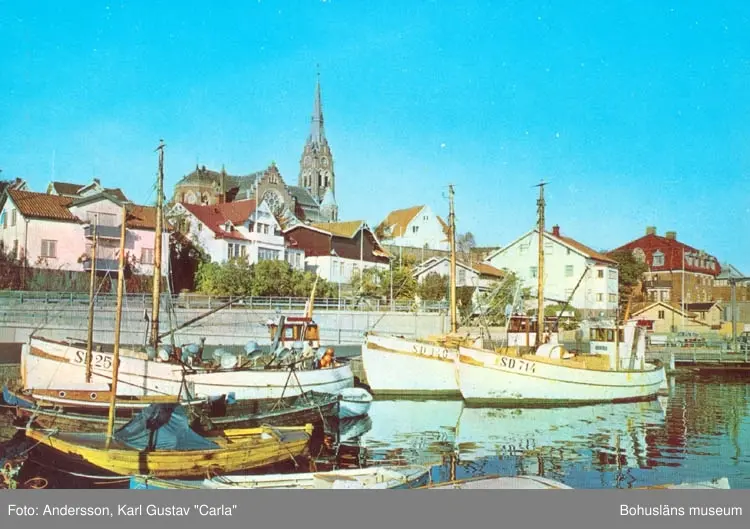 Tryckt text på kortet: "Lysekil, Södra hamnen från T- bryggan".
VACKRASTE VÄGEN TILL OCH FRÅN LYSEKIL GÅR ÖVER ELLÖS OCH GULLMARSFÄRJORNA".
"CARLA - FÖRLAGET LYSEKIL, 0523/10919, 10320".