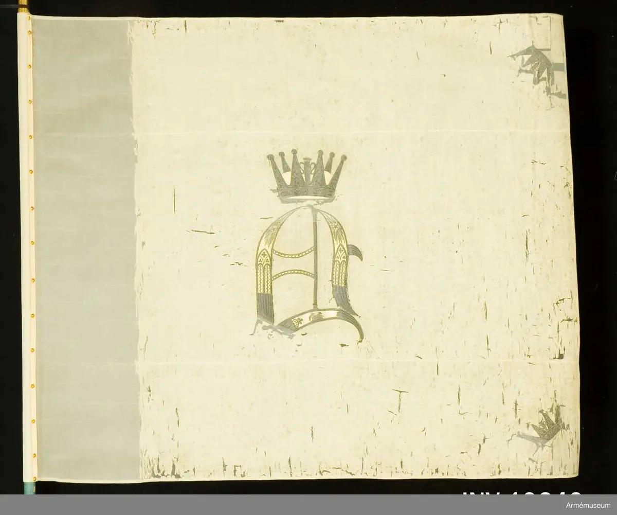 Duken vit med i guld broderat anglosachsiskt O under furstlig krona. På tillhörande lapp av äldre modell anges att Visby stads beväringsbataljon erhöll fanan 1832.