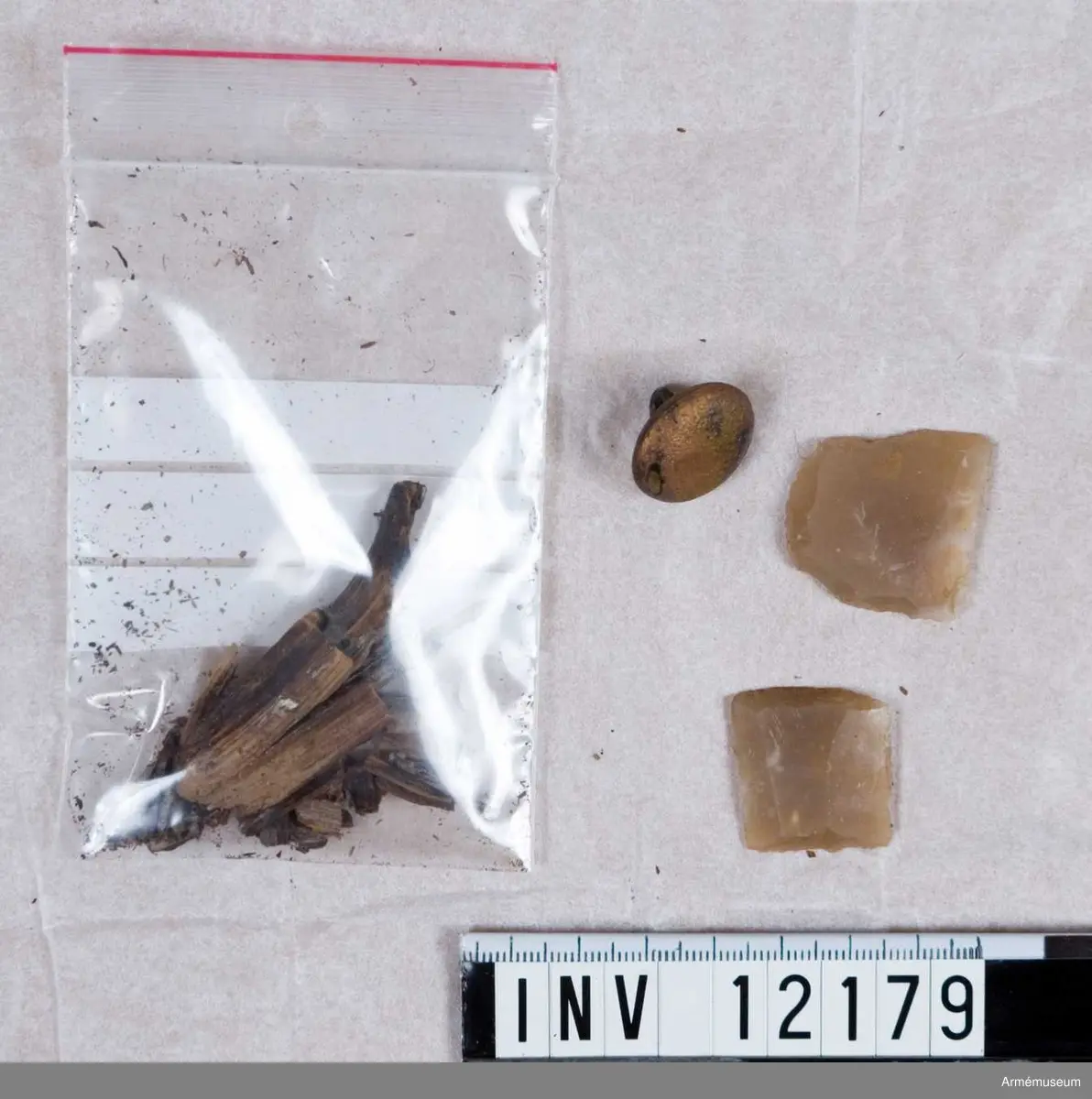 Grupp C I.
Dräktfragment med knappar. Jordfynd 1959, Blidö Furusund Tullåkern.