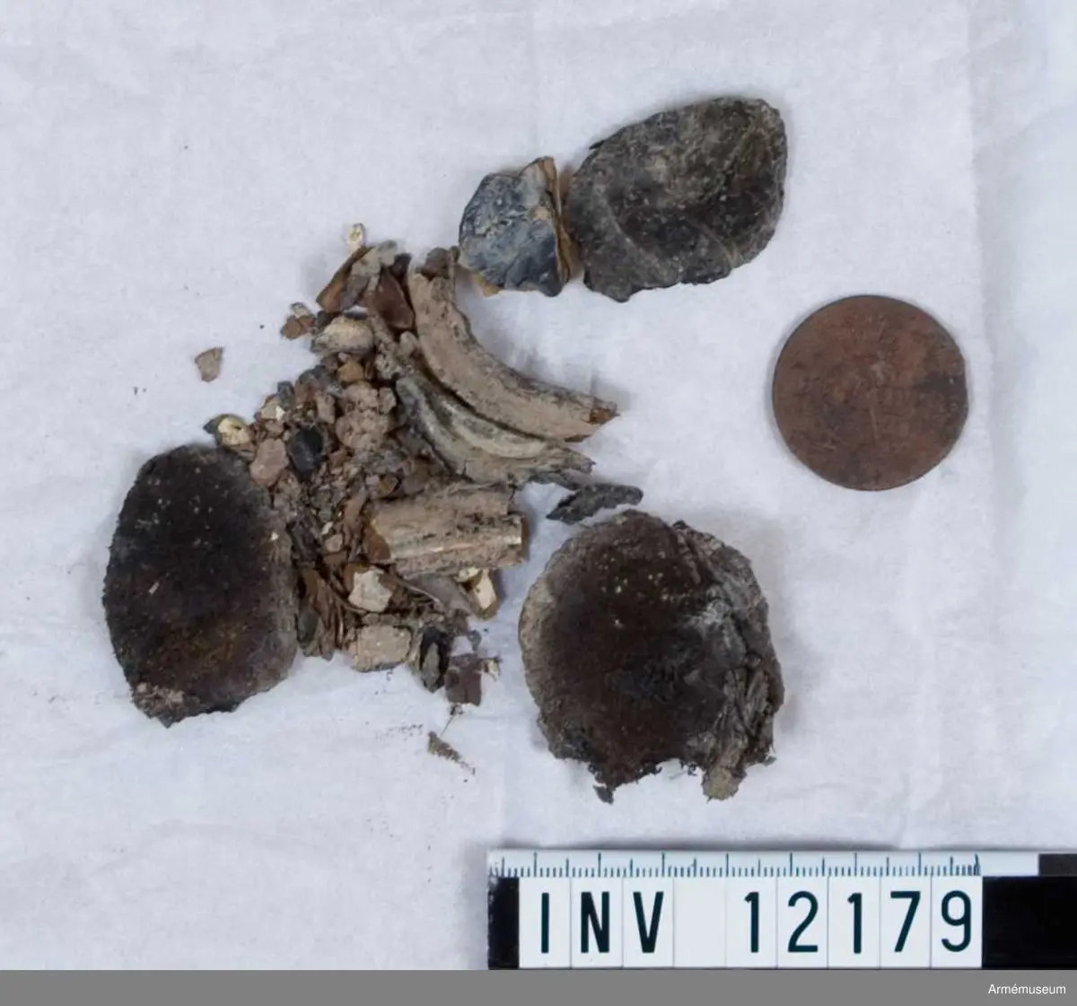 Grupp C I.
Dräktfragment med knappar. Jordfynd 1959, Blidö Furusund Tullåkern.