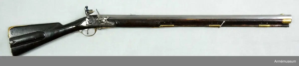 Pipan är åttkantig. Längst bak är tjockleken 3,4 cm, över mellanrörkan är den 2,8 cm och vid mynningen är den 3,1 cm ("stukat gods"). Loppet har åtta halvrunda spiralräfflor, som gör 3/4 varv på piplängden. Ett med fot försett järnsikte sitter inlaxat i pipans omkr 14 cm framför bakänden. Ett mässingskorn, som har laxfot sitter 2,9 cm bakom mynningen. På pipans översida krönt N T (Norrtälje). På undersidan ett R och ett P. Pipan har häften och fasthålles med stift. 

Låset har platt, med bräckta kanter och försänkt bakspets försett bleck. Pannskruven går inifrån men skruven för eldstålsfjädern går utifrån. Hanen har varhake och fängpannan har både eldskärm och arm, som stöder eldstålsskruven. På bleckets utsida under eldstålsfjädern stämpel med C B.

Stocken är av björk och svart. Framstocken är falsad längs laddstocksrännans kanter och vid svansskruvsstjärtens slut finns ett enkelt bladornament. På kolvens högra sida en med skjutlock försedd kolvlåda. På samma sida är nummret 149 inslaget, men på vänstra sidan står siffran 2. 

Alla beslag är av mässing. Sidblecket är stort, platt med bräckta kanter, nära nog trekantigt, dock med de två översidorna fasonerade. Bakplåten har spets, som går in över kolvryggen och som där är fäst med en skruv. I själva bakplåten sitter två skruvar, som ha utstående huvud. Varbygeln är rätt låg. Dess främre arm har docka, den bakre fasthålles av två skruvar. De tre släta, rätt långa rörkorna är litet kullriga samt ha förstärkt bak- och framkant. Näsblecket fasthåles av ett stift. Den främre rembygelns skruv går genom framstocken litet framför mellanrörkan, men den nedre rembygelns går genom varbygelns främre del.Laddstocken är av trä. Tjockänden är skodd med horn. På smaländen sitter ett rätt långt järnbeslag, som har ett gängat hål för kratsen. I kolvlådan förvaras en krats.
