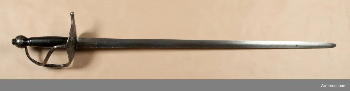Klingan har på var sida tre stämplar och upptill på kvartsidan dessutom P-stämpel. Fästet är svärtat. Kavellindningen är av mässingstråd. Tumbygel saknas.
Värjan är ursprungligen en infanterivärja m/1685, som förkortats och vars tumbygel borttagits.