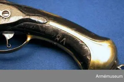 Pistol med flintlås.
Beslag av mässing. Laddstock av trä med mässingsbeslag. På kammarstycket ett krönt F samt bokstaven Ö. På kolvhalsen en mässingsmedaljong med Gustaf III:s krönta namnschiffer. På kolvhalsens H sida nummer 25 inskuret och på dess motsvarande bokstäverna V B. Vid kolvknappen en ring av järn fästad, pistolen tycks vara par med AM 1932:4769.