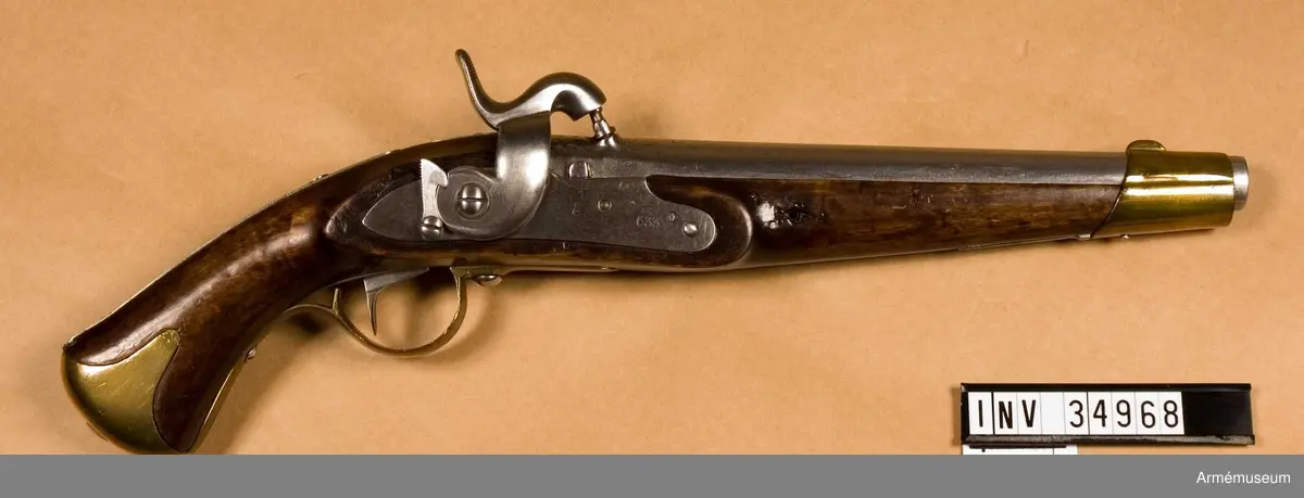 Tappstudsarpistol med slaglås.
Spetskulan l:23.16 mm, d:15,55 mm, vikt 25,88 gram. Krutladdningens vikt 3,31 gram. Fyra räfflor. Räffelstigning: Ett halvt varv på piplängden. Pistolen är ursprungligen en i Carl gustafs stads gevärsfaktori 1837 tillverkad studsarepistol med flintlås där låset 1850 ändrats till slaglås och pipan försetts med tapp enligt en 1849 fastställd förändringsmodell. Det gamla fänghålet är tärnat och en utstående järntapp anger dess plats. Knallhattstappen är inskruvad direkt i pipan litet till höger om siktlinje. På pipans vänstra platt står 3 och AM, på pipans udersida 1837, EH, P2, IF. 663 och  1850.

Den vid ändringen tillkomna slaglåshanen är kullrig och svängd ganska mycket in över pipan. Halvspännet är högt, men i hakspänn står hanens slagyta blott obetydlig över knalhattsstappen. På låsbleckets utsida står krönt C och 633, på insidan ÅG, 1837 och AM. På stockens vänstra sida bakom sidblecket är inslaget numret 633. På sidbleckets och näsbandets insida är inslaget ett B och på kolvkappans vänstra flik stå 5 och 70. På de skruvar som fasthåller anslagsjärnet, är numret 21 inslaget.