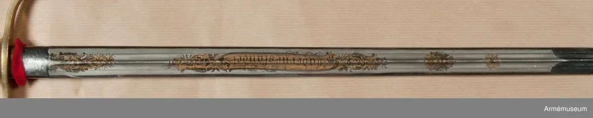 Klingbredd upptill 222 mm. Sabeln är fullkomligt AM 39928 men klingan är kortare. Den officiella längden på klingor m/1899 är 80 cm. Vid vapnet är fästat en fastställningslapp.