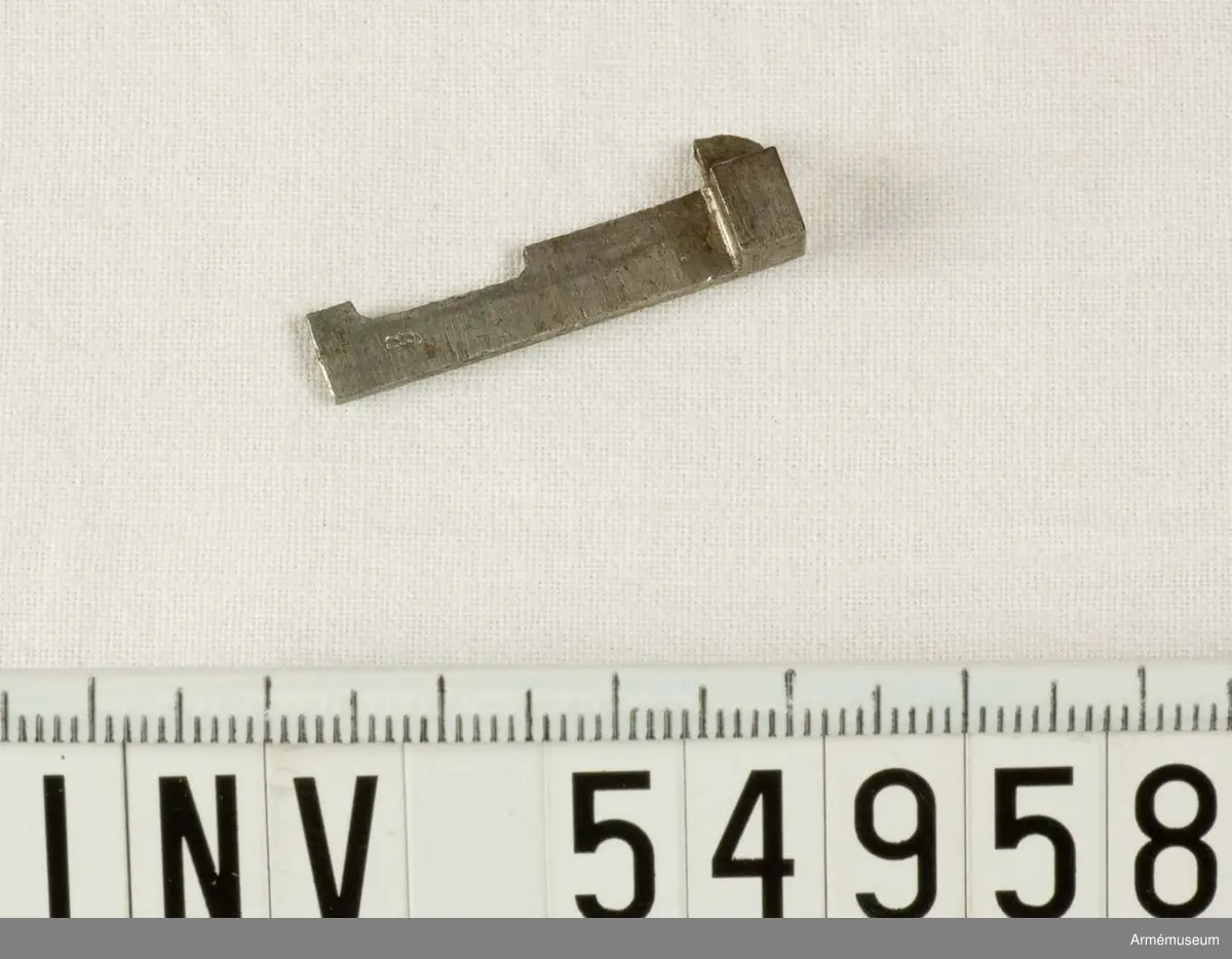 Grupp E VIII. 

Del till pipa. Nr 8 (av tio) i tillverkningsordningen.
Gevärsdel t 1867 års gevär m/1867; en av c:a 400 delar. 