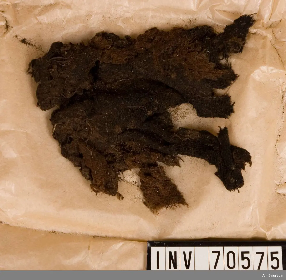 Grupp C:I. 
Funna vid grävningar sommaren 1939. Gravfynd från Sandhamn bestående av knappar och tygrester