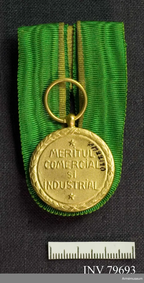På ena sidan en bild av kungen omgiven av orden: "CAROL I REGE AL ROMANIEI". På kanten en krans av eklöv.

På andra sidan står i mitten: "MERITUL COMERCIAL ȘI INDUSTRIAL". På kanten en krans av eklöv.
